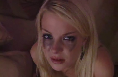 A close-up of a blonde woman's face. Her black makeup runs down her face due to crying.