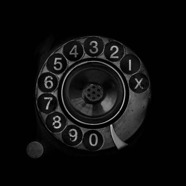 Unique rotary phone with speaker in the center of the circle of numbers.